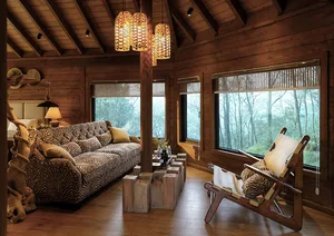A cozy living room with a wooden ceiling, log walls, and a comfortable sofa with a zebra print cover, surrounded by large win