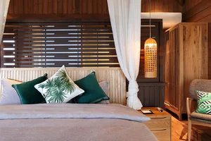 A modern bedroom featuring wooden decor and white curtains.