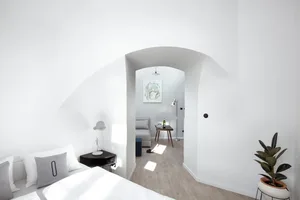 Minimalist bedroom featuring a wood floor and white walls.