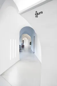 A minimalist office space with white walls and concrete surfaces.