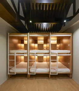 Minimalist hostel room with wood paneling and bunk beds.