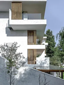 Modern residential exterior with concrete finish and wooden accents.