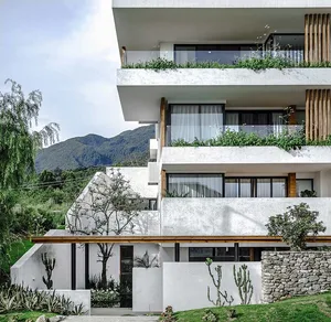 A modern residential building with multiple stories featuring concrete, glass, and wood materials.
