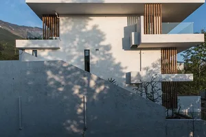 Modern house featuring a concrete exterior with wooden accents and large windows.