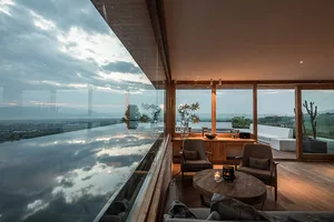Modern living room featuring glass paneled ceiling and exterior view.