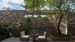 Minimalist garden featuring stone walls and seating
