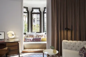 A cozy living room with a white tufted sofa, fabric cushions, and a glass coffee table.