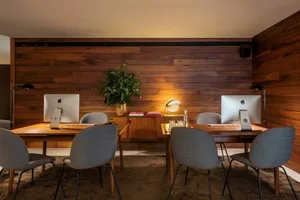Modern, industrial-style office coworking space with wooden walls and furniture.