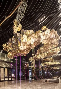 A lobby featuring a modern interior design with metallic disk chandeliers