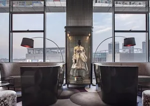Modern hotel lobby featuring glass enclosed display and stylish seating with floor-to-ceiling windows.