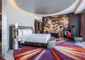 A modern hotel suite featuring contemporary furniture and a vibrant rug.