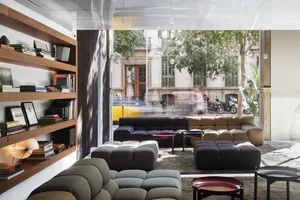 Modern interior design living room with cozy seating arranged in a U-shape, featuring a large glass wall with an urban view, 