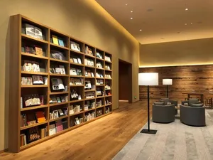 A spacious, modern library with wooden shelves filled with various books andKnock Knock Wood Cutting Board - Cherry Blossom (