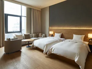 Modern, minimalist bedroom with twin beds, white bedding, and a contemporary design.