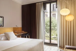 A modern bedroom with a clean, minimalist design featuring neutral-toned fabrics and furniture.