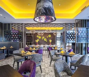 A modern restaurant interior with purple chairs, yellow napkins, and a geometric pattern on the ceiling and walls.