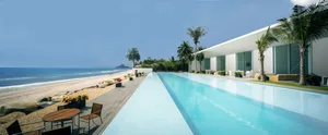 Luxurious vacation resort with a long, modern pool and ocean view.
