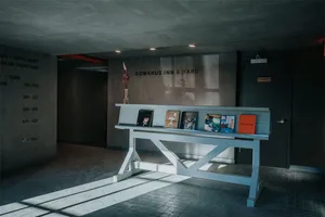 Concrete lobby space with books, vase, and industrial-style decor.