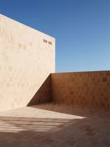 A minimalist architectural space featuring a terracotta exterior wall.