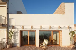 Modern building exterior featuring brick, glass, and terracotta materials.