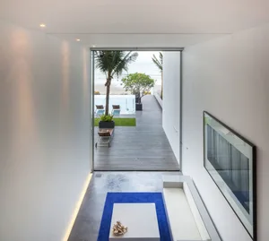 A modern residential entryway featuring a concrete floor and minimalist design.
