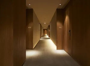 A modern hotel corridor with wood paneling.