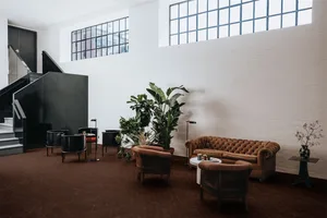 An industrial-style lobby with brick walls and large windows.