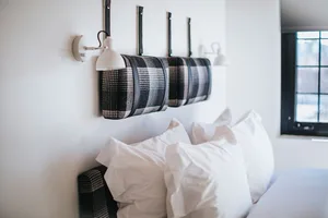 A modern bedroom with a black and white checkered headboard and white bedding.