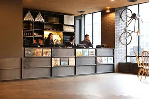 Industrial hotel lobby featuring a metal reception desk with a mixed media design element.
