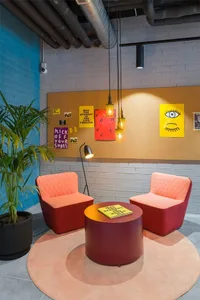A modern lobby featuring fabric furniture and industrial lighting.