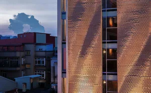 A brick building with a sunset casting a warm glow on its facade.
