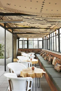 Modern cafe interior featuring minimalist wood tables, concrete flooring, and textured textiles