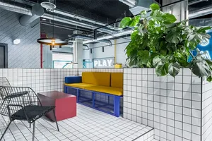 Industrial-style office space featuring white tiled floor, concrete walls, and steel beams