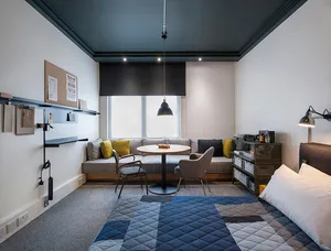 Modern minimalist apartment featuring white, gray, and blue color palette with clean lines and simple furnishings.