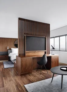 A minimalist bedroom featuring wooden furniture and a large window with a city view.