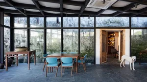 A modern dining room featuring a concrete floor and large glass windows.