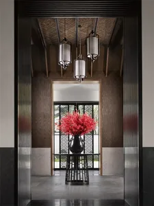 A modern interior entryway featuring a metal wall and decorative lighting.