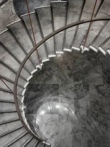 A modern, glass staircase with polished marble flooring.