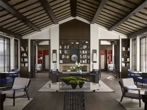 Contemporary living room with wooden and concrete finishes, featuring comfortable seating and a central coffee table.