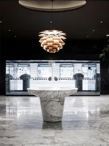 Modern lobby interior with marble table and glass walls.