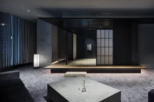 一間現代簡約客廳，搭配混凝土桌與木地板。