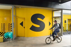A modern street entrance with bright yellow paint.