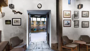 Concrete wall and floor of a cafe interior with framed artwork on the walls.