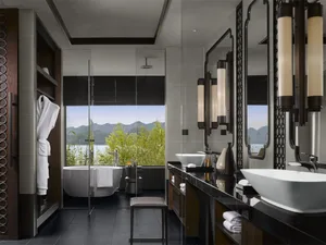 A modern bathroom featuring grey tiles and glass elements