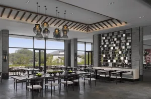 A spacious, modern restaurant interior with large windows, contemporary furniture, and minimalist decor.