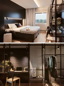 A modern hotel room featuring a black accent wall, a comfortable bed, and a sleek desk area with a wardrobe.