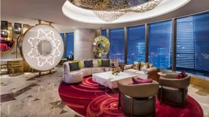 Modern hotel suite featuring marble, glass, and fabric materials.