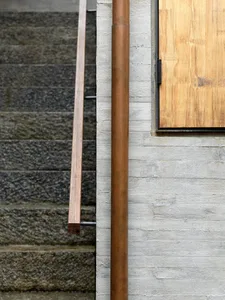 Concrete staircase with wooden handrail and metal railing