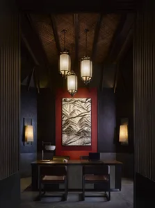 Luxurious office reception desk featuring dark wood materials and elegant lighting fixtures.