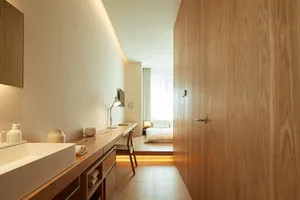 A minimalist bedroom featuring wood finishes and a simple, functional design.